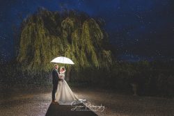 Kedleston Country House wedding photography storm amy rain umbrella creative in front of willow tree